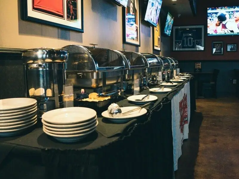 A long buffet line of chafing dishes set for a party
