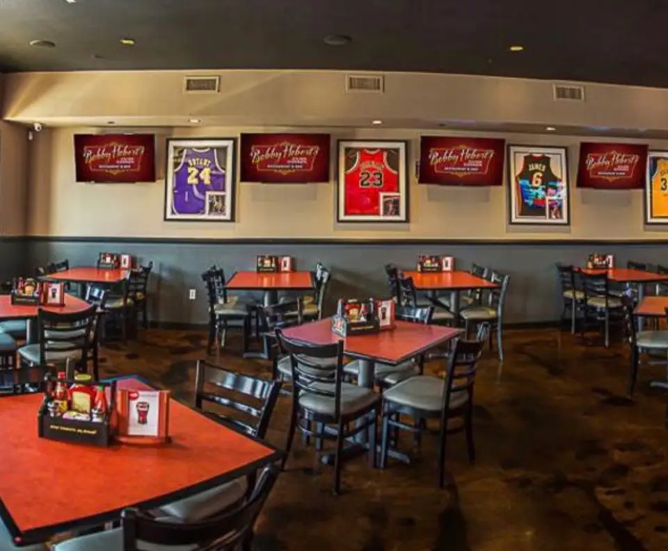 The Endzone party room: rows of tables under framed jerseys and Bobby Hebert’s TVs