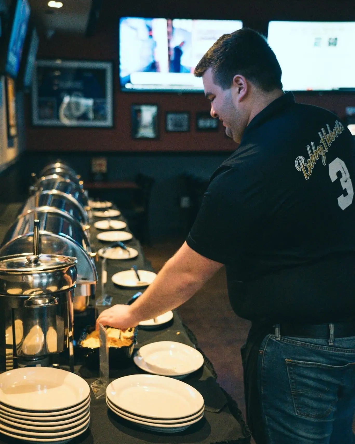 A Bobby Hebert’s team member setting up a catering buffet