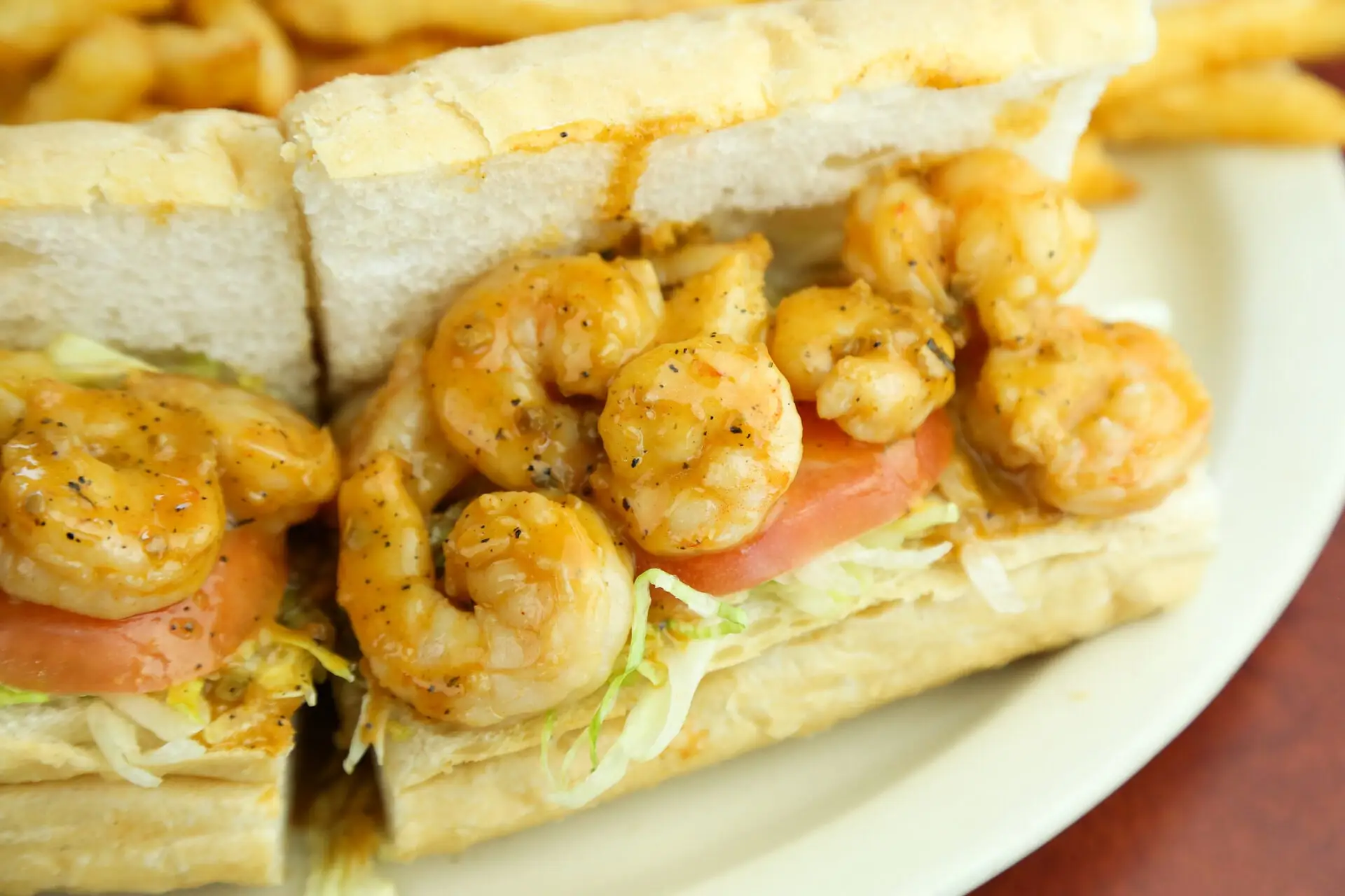 Fried Gulf shrimp po’boy dressed with lettuce and tomato on French bread